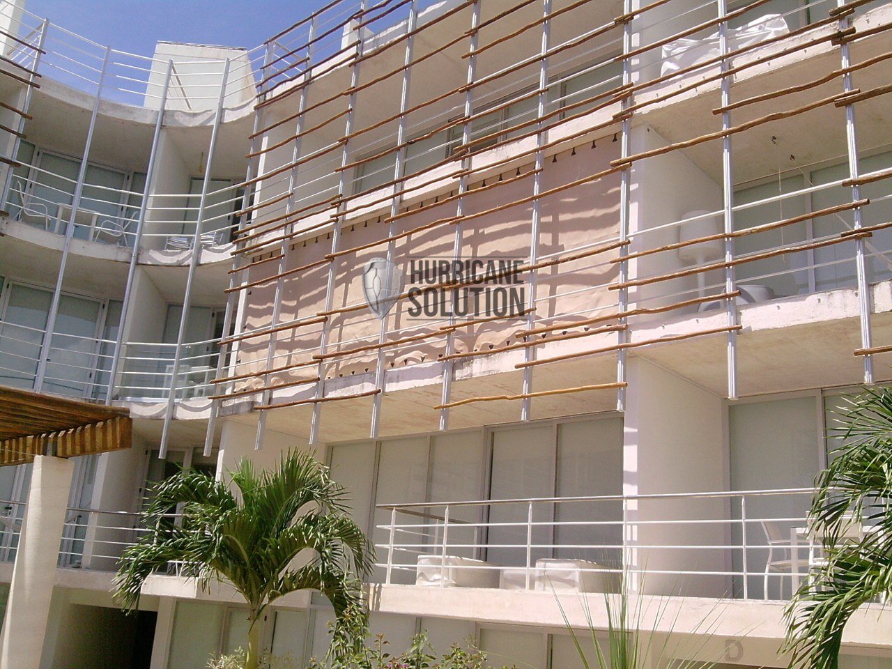 Hurricane Solution protective fabric covering a multistory opening behind scaffolding.