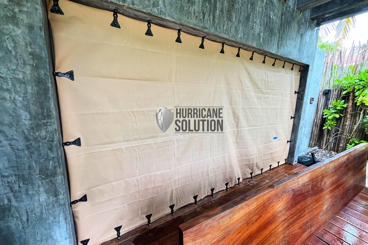 Hurricane Solution screen secured with black perimeter clips across an interior opening beside a wooden floor.