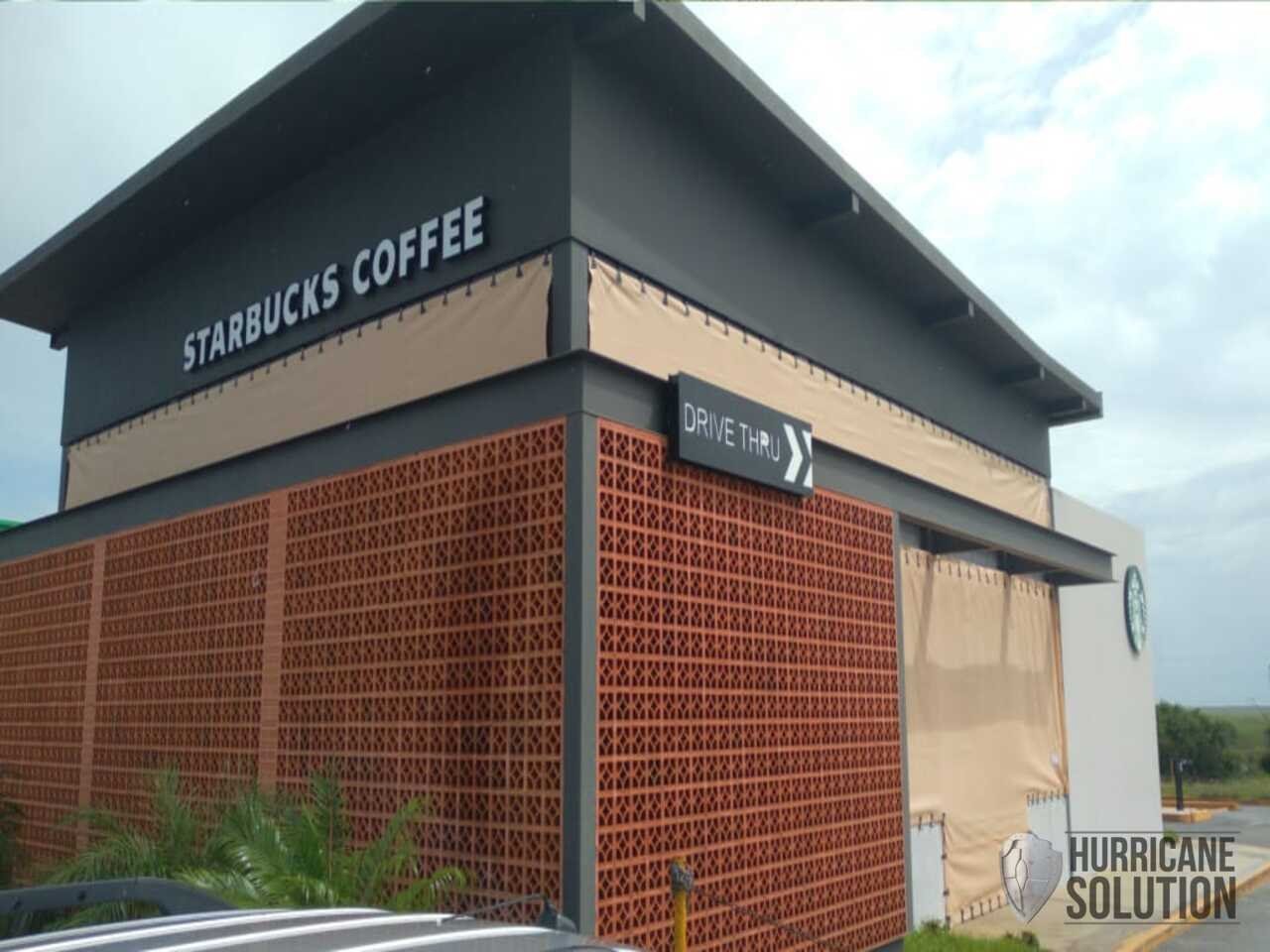 Starbucks facade with a Hurricane Solution fabric screen secured around a side opening.